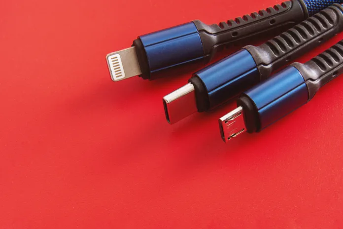 "USB Cables on Red Background" - A close-up of USB-C, lightning, and micro USB cables with black and blue colors on a red background.